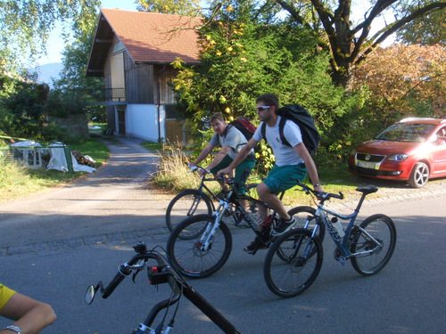 Two guys on bikes recovering a third bike.